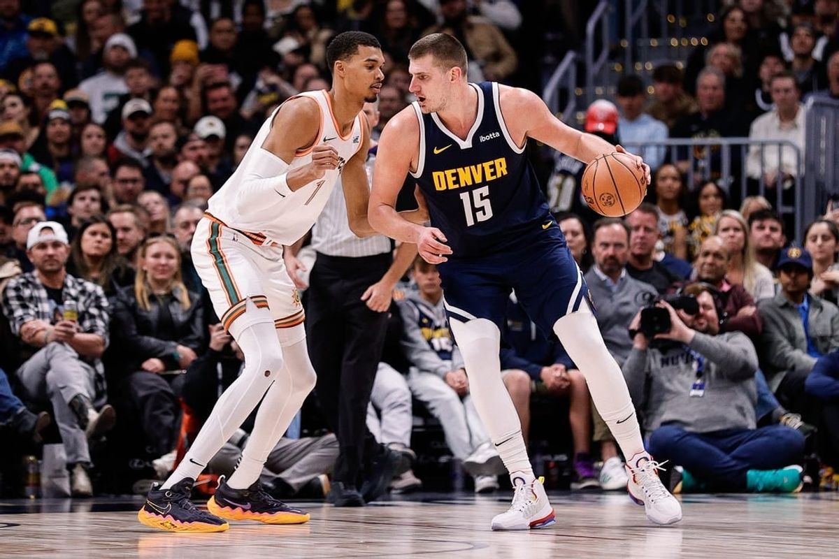 Nov 26, 2023; Denver, Colorado, USA; Denver Nuggets center Nikola Jokic (15) controls the ball as San Antonio Spurs center Victor Wembanyama (1) guards in the third quarter at Ball Arena.