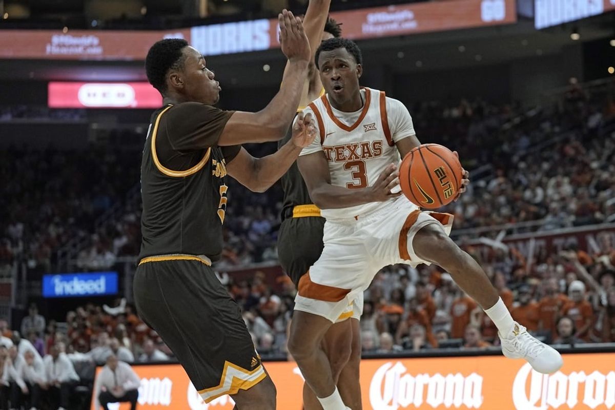Nov 26, 2023; Austin, Texas, USA; Texas Longhorns guard Max Abmas (3) passes the ball while defended by Wyoming Cowboys forward Cam Manyawu (5) during the first half at Moody Center.