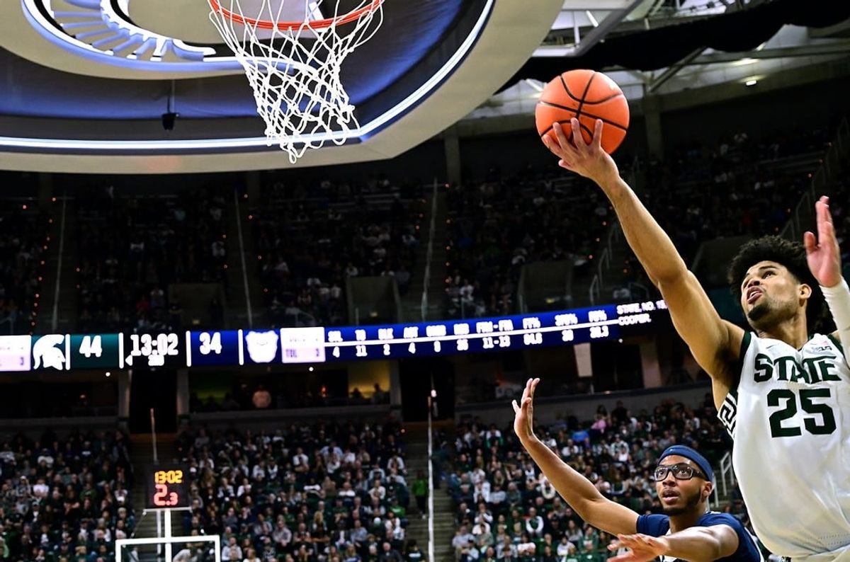 Nov 17, 2023; East Lansing, Michigan, USA; Michigan State Spartans forward Malik Hall (25) puts a shot off the glass past Butler Bulldogs center Andre Screen (23) during the second half at Jack Breslin Student Events Center.