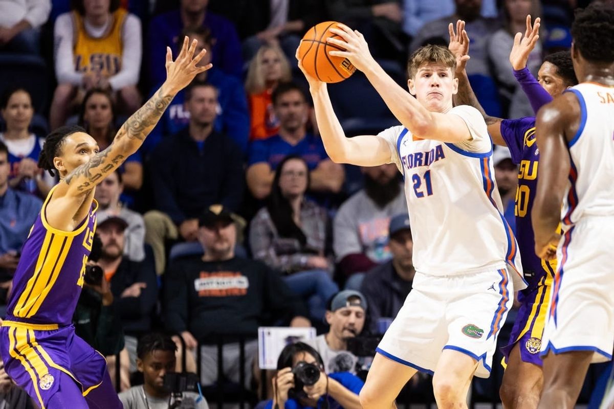 Feb 13, 2024; Gainesville, Florida, USA; Florida Gators forward Alex Condon (21) looks to pass away from LSU Tigers forward Tyrell Ward (15) and LSU Tigers forward Derek Fountain (20) during the first half at Exactech Arena at the Stephen C. O'Connell Center.