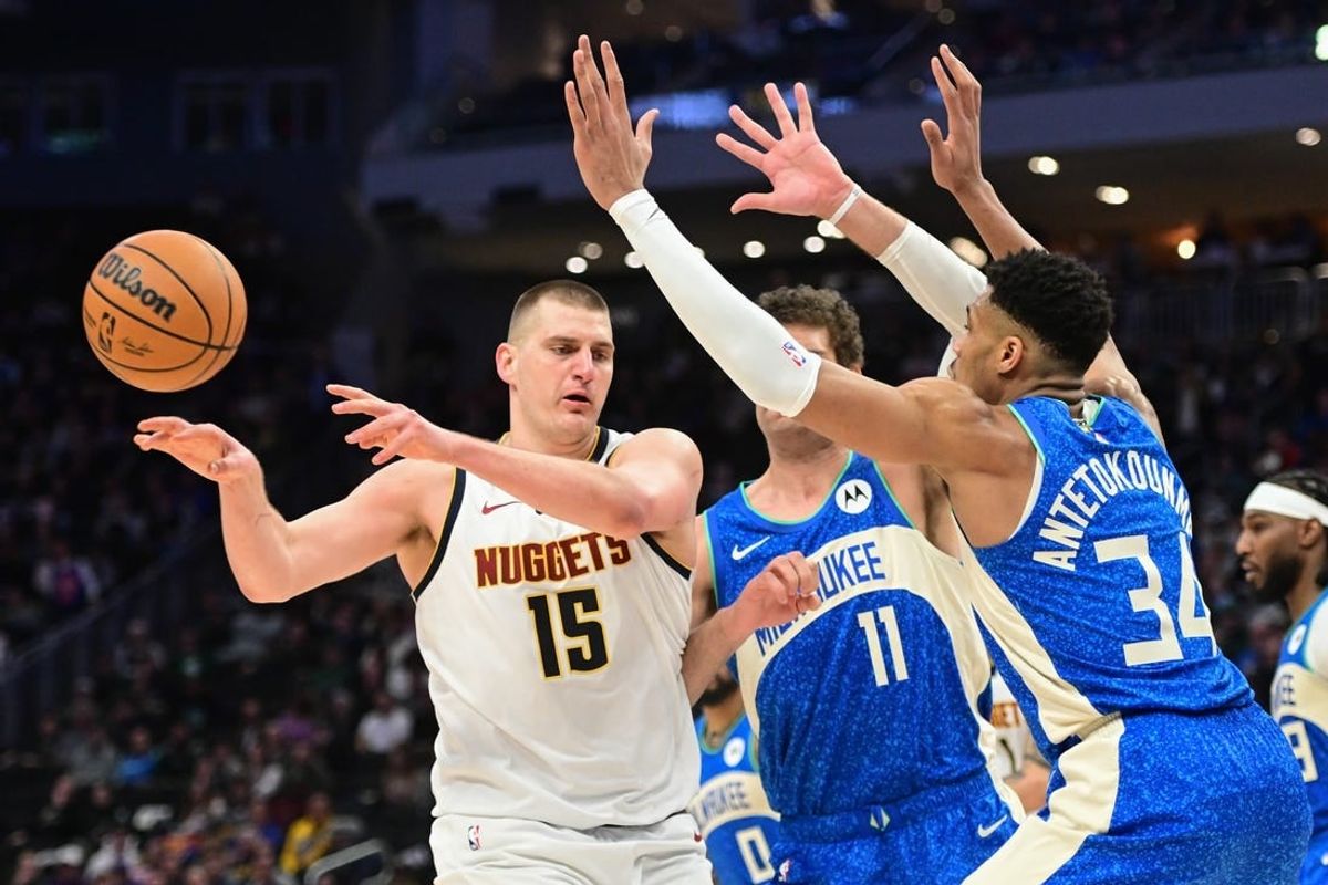 Feb 12, 2024; Milwaukee, Wisconsin, USA; Denver Nuggets center Nikola Jokic (15) passes against Milwaukee Bucks forward Giannis Antetokounmpo (34) in the third quarter at Fiserv Forum.