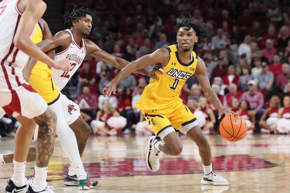 Nov 17, 2023; Fayetteville, Arkansas, USA; UNC Greensboro Spartans guard Keyshaun Langley (0) dribbles around Arkansas Razorbacks guard Truman Mark (12) during the first half at Bud Walton Arena.