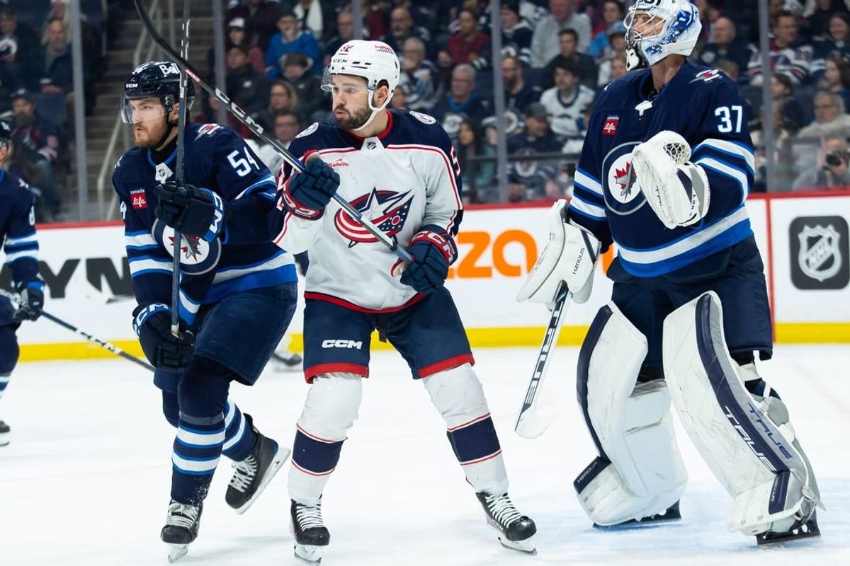 Jan 9, 2024; Winnipeg, Manitoba, CAN; Columbus Blue Jackets forward Emil Bemstrom (52) jostles for position with Winnipeg Jets defenseman Dylan Samberg (54) during the first period at Canada Life Centre.