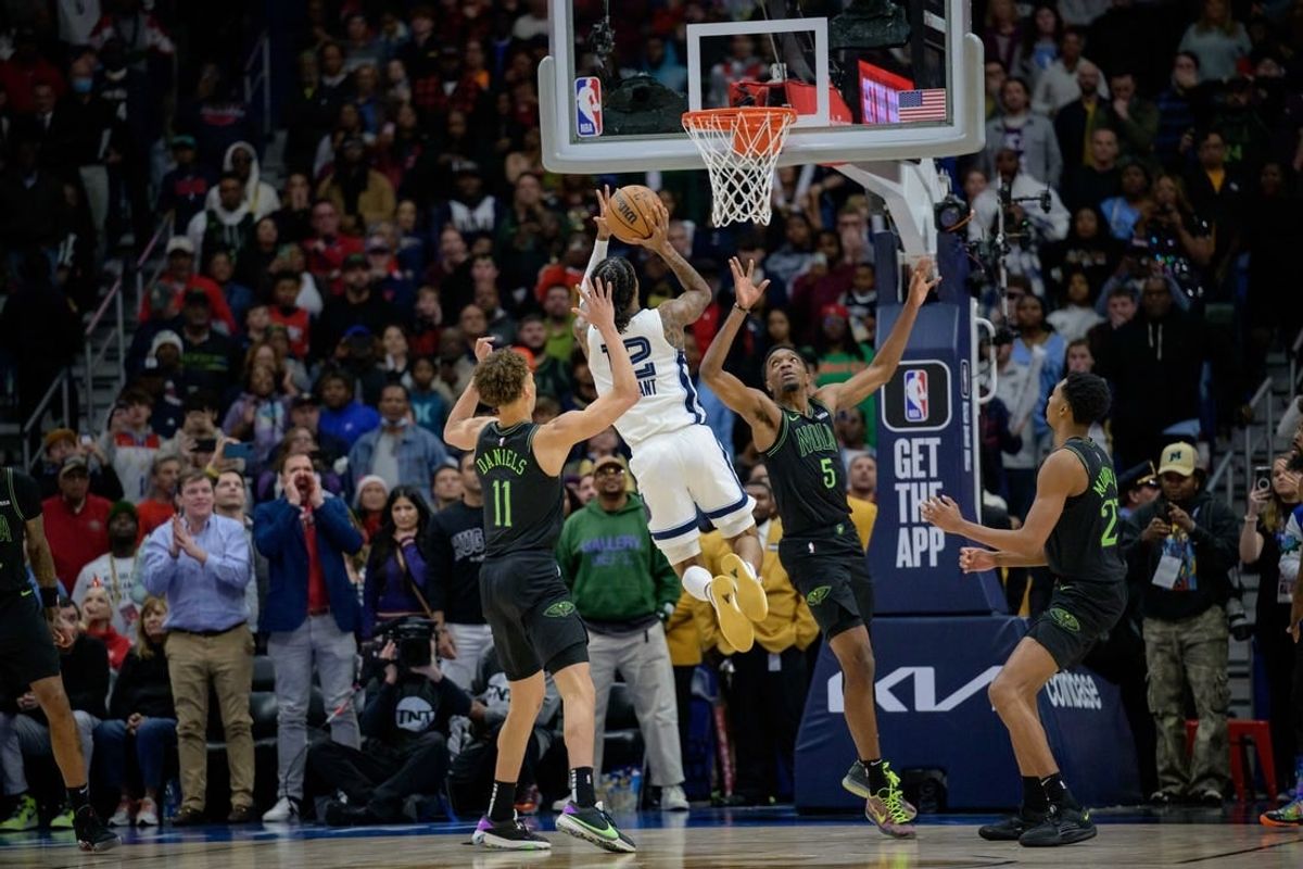Dec 19, 2023; New Orleans, Louisiana, USA; Memphis Grizzlies guard Ja Morant (12) attempts the game winning basket against New Orleans Pelicans guard Dyson Daniels (11) and forward Herbert Jones (5) during the fourth quarter against the New Orleans Pelicans at the Smoothie King Center.
