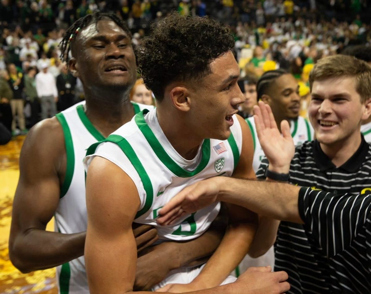 Oregon   s Jackson Shelstad, center, is mobbed by teammates after sinking the game winning shot against Michigan in overtime at Matthew Knight Arena in Eugene Saturday, Dec 2, 2023.