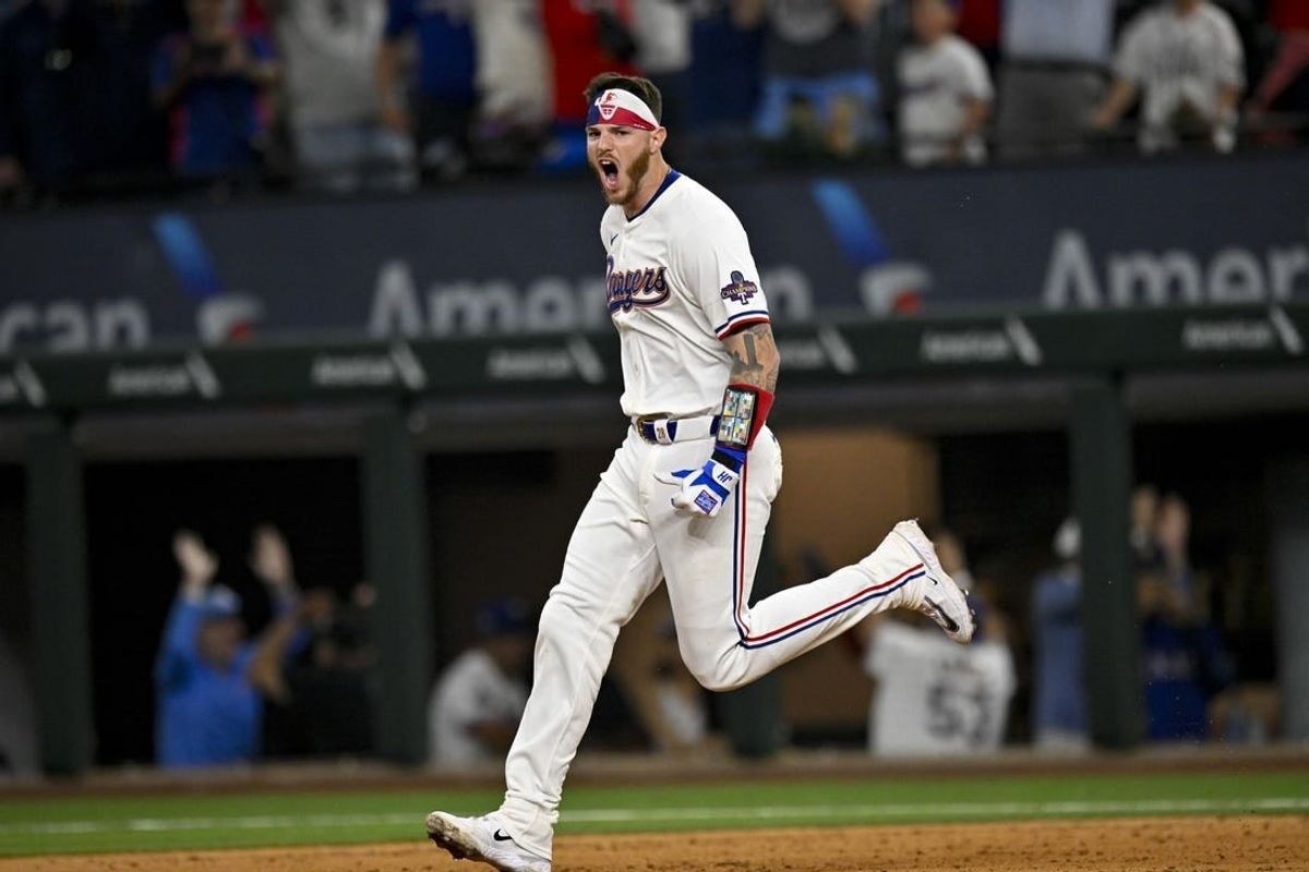 Mar 28, 2024; Arlington, Texas, USA; Texas Rangers catcher Jonah Heim (28) celebrates after he hits a walk off single against the Chicago Cubs during the tenth inning at Globe Life Field.