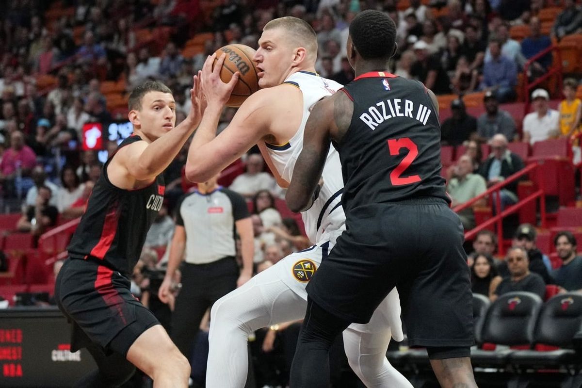 Mar 13, 2024; Miami, Florida, USA;  Denver Nuggets center Nikola Jokic (15) drives to the basket as Miami Heat guard Terry Rozier (2) and Miami Heat forward Nikola Jovic (5), right, defend during the first half at Kaseya Center.