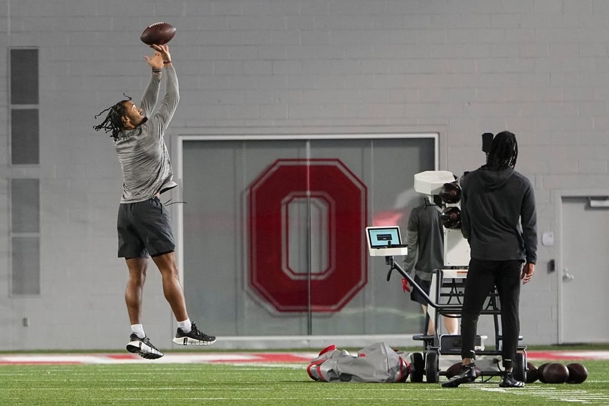 Mar 4, 2024; Columbus, OH, USA; Ohio State Buckeyes wide receiver Emeka Egbuka tosses a ball to Marvin Harrison Jr. at the start of spring practice at the Woody Hayes Athletic Center.