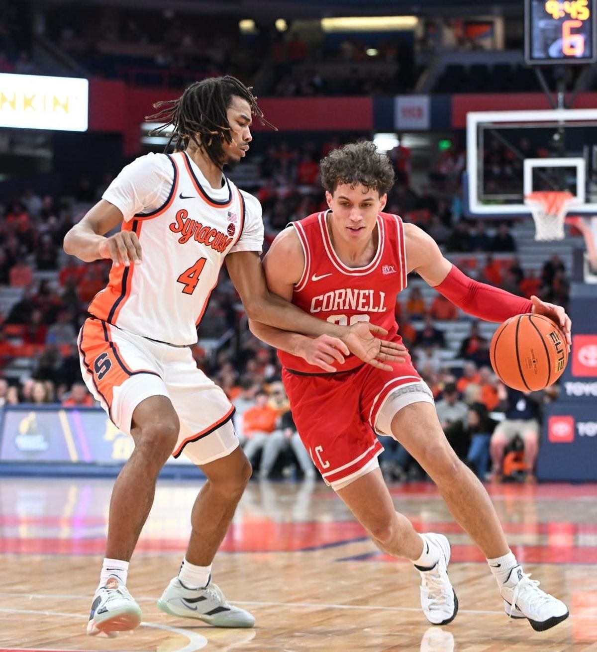 Dec 5, 2023; Syracuse, New York, USA; Cornell Big Red guard Chris Manon (30) tries to move the ball past Syracuse Orange forward Chris Bell (4) in the first half at the JMA Wireless Dome.