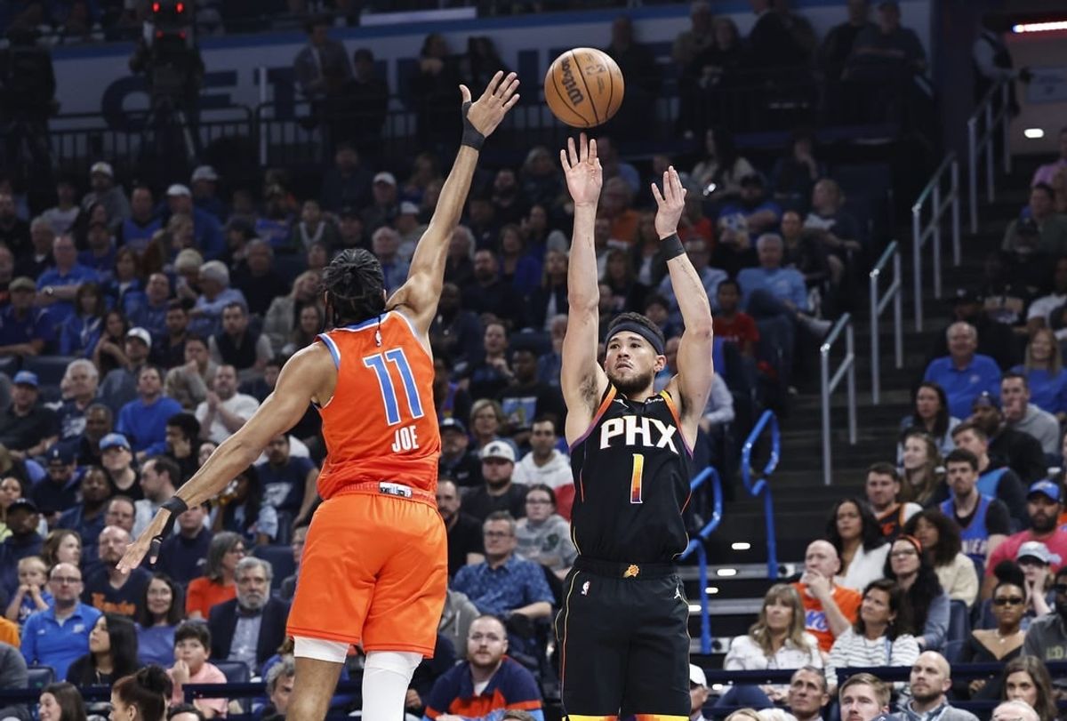 Mar 29, 2024; Oklahoma City, Oklahoma, USA; Phoenix Suns guard Devin Booker (1) shoots a three-point basket as Oklahoma City Thunder guard Isaiah Joe (11) defends during the first half at Paycom Center.