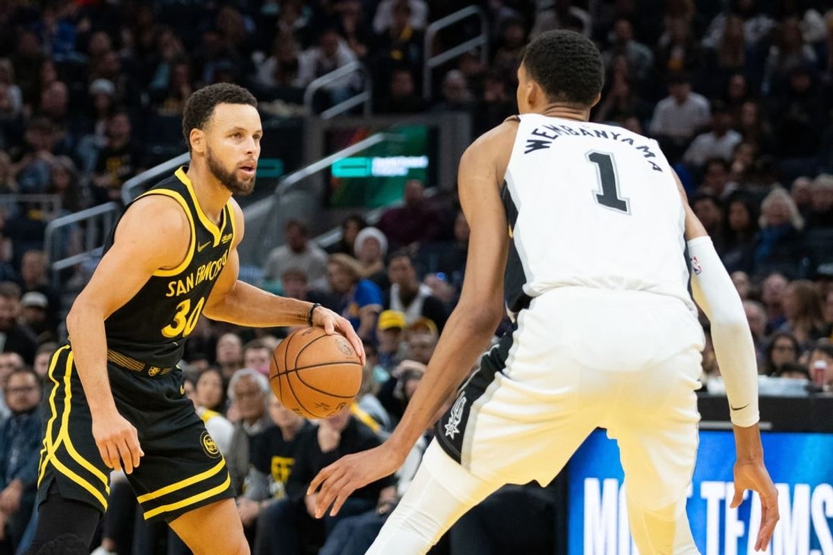 November 24, 2023; San Francisco, California, USA; Golden State Warriors guard Stephen Curry (30) dribbles the basketball against San Antonio Spurs center Victor Wembanyama (1) during the fourth quarter at Chase Center.