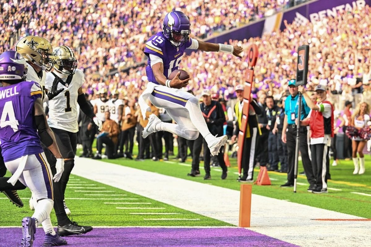 Nov 12, 2023; Minneapolis, Minnesota, USA; Minnesota Vikings quarterback Joshua Dobbs (15) scores on a touchdown run as New Orleans Saints cornerback Alontae Taylor (1) look on during the second quarter at U.S. Bank Stadium.