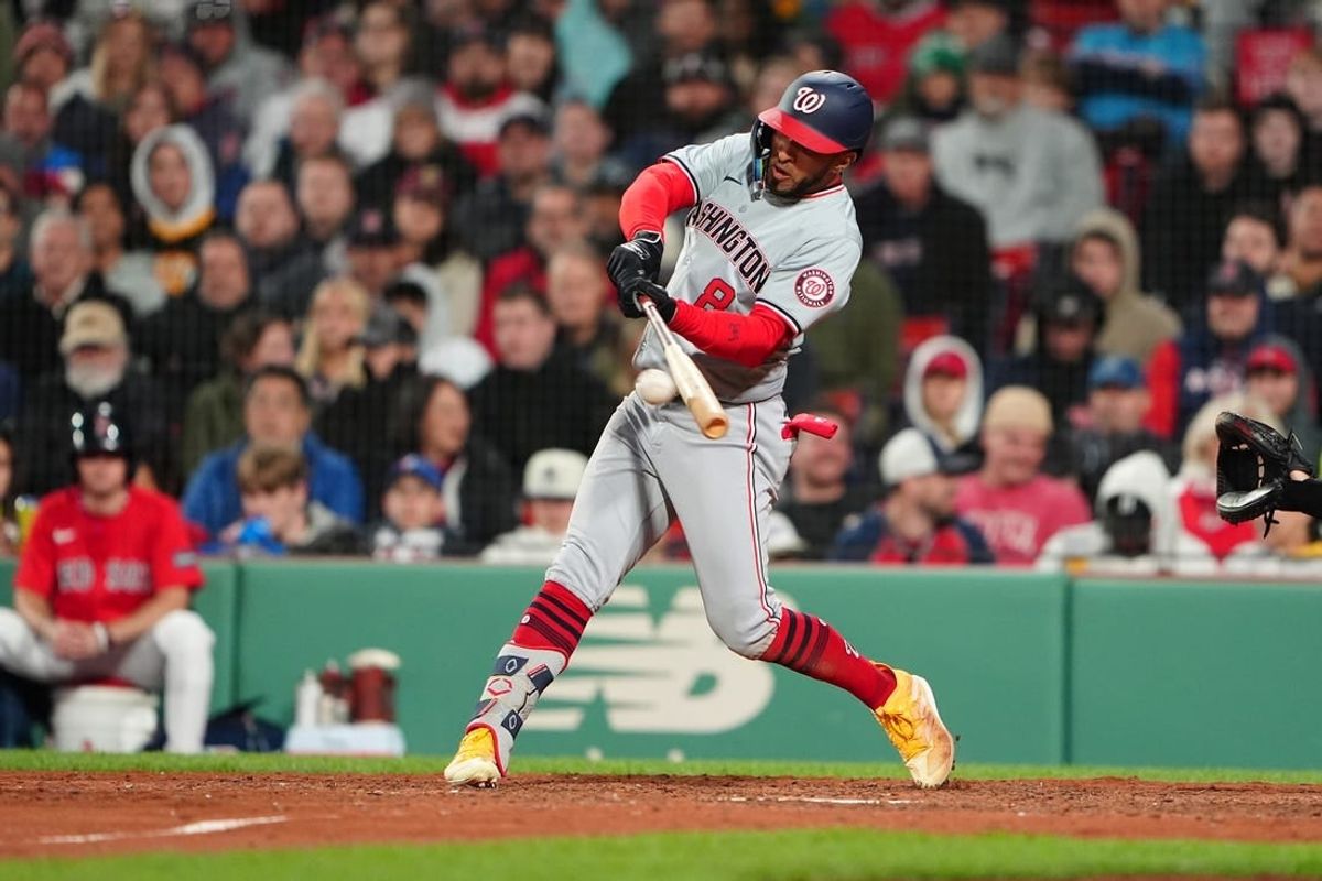 May 10, 2024; Boston, Massachusetts, USA; Washington Nationals left fielder Eddie Rosario (8) hits a single against the Boston Red Sox during the ninth inning at Fenway Park.