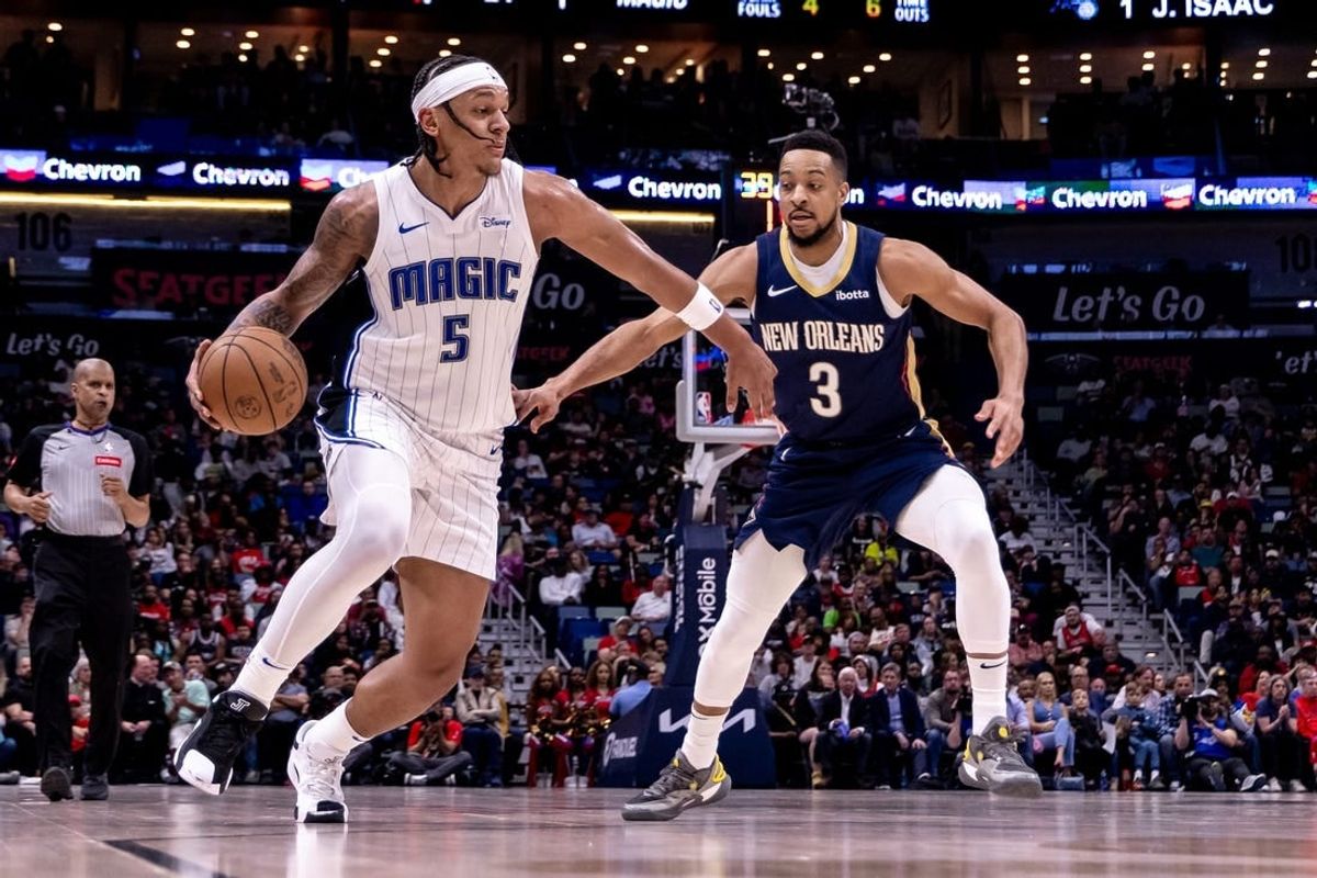 Apr 3, 2024; New Orleans, Louisiana, USA;  Orlando Magic forward Paolo Banchero (5) dribbles against New Orleans Pelicans guard CJ McCollum (3) during the first half at Smoothie King Center.