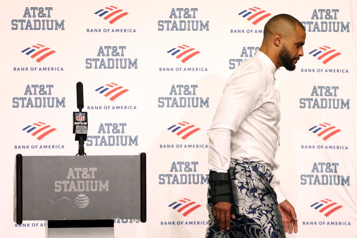 Dak Prescott walks away from the podium with a splint around his injured hand.