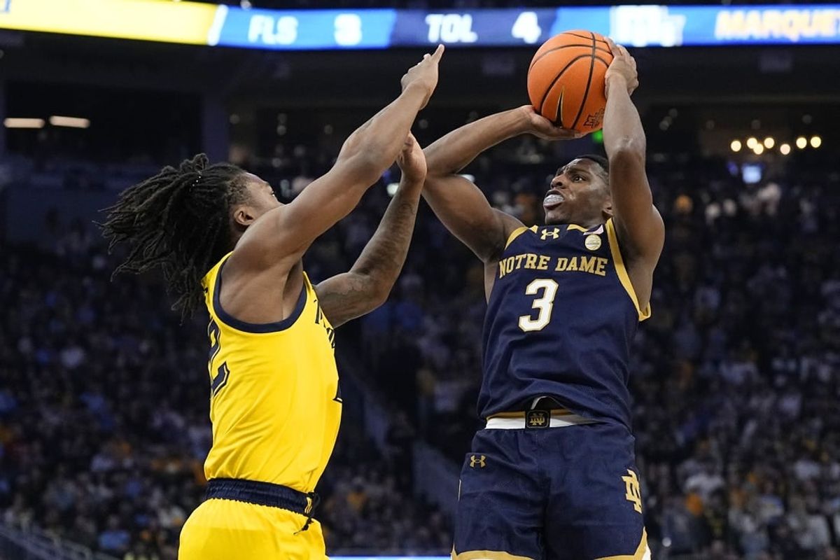 Dec 9, 2023; Milwaukee, Wisconsin, USA;  Notre Dame Fighting Irish guard Markus Burton (3) shoots against Marquette Golden Eagles guard Sean Jones (22) during the first half at Fiserv Forum.