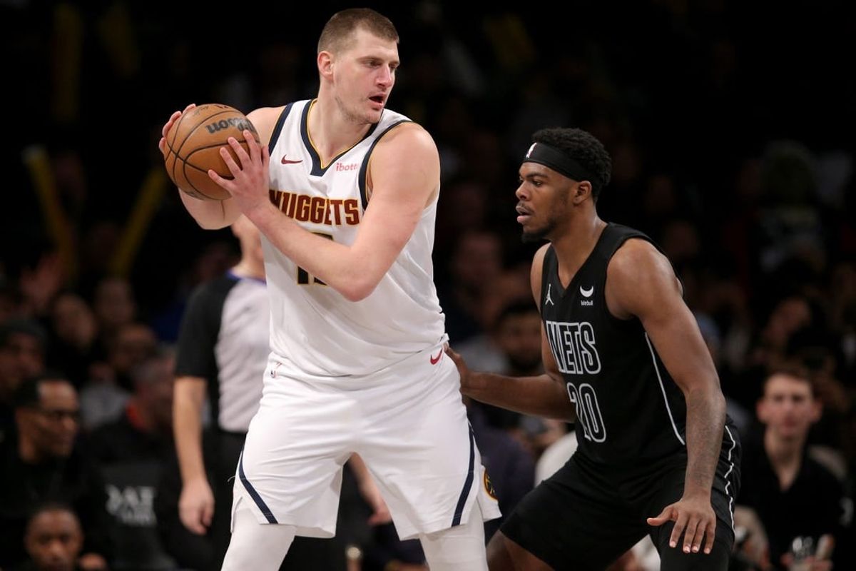 Dec 22, 2023; Brooklyn, New York, USA; Denver Nuggets center Nikola Jokic (15) controls the ball against Brooklyn Nets center Day'Ron Sharpe (20) during the fourth quarter at Barclays Center.