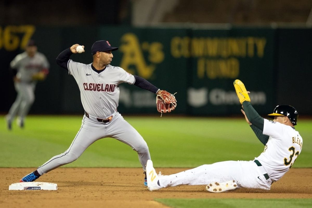 Mar 28, 2024; Oakland, California, USA; Cleveland Guardians shortstop Brayan Rocchio (4) throws over Oakland Athletics center fielder JJ Bleday (33) to complete a double play during the fourth inning at Oakland-Alameda County Coliseum. Seth Brown was out at first base.