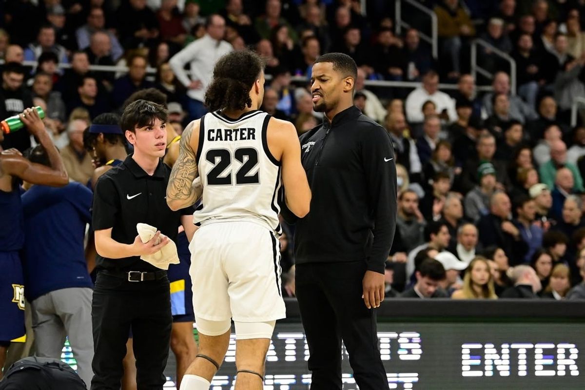 Dec 19, 2023; Providence, Rhode Island, USA; Providence Friars coach Kim English checks on an injured guard Devin Carter (22) during the first half against the Marquette Golden Eagles at Amica Mutual Pavilion.