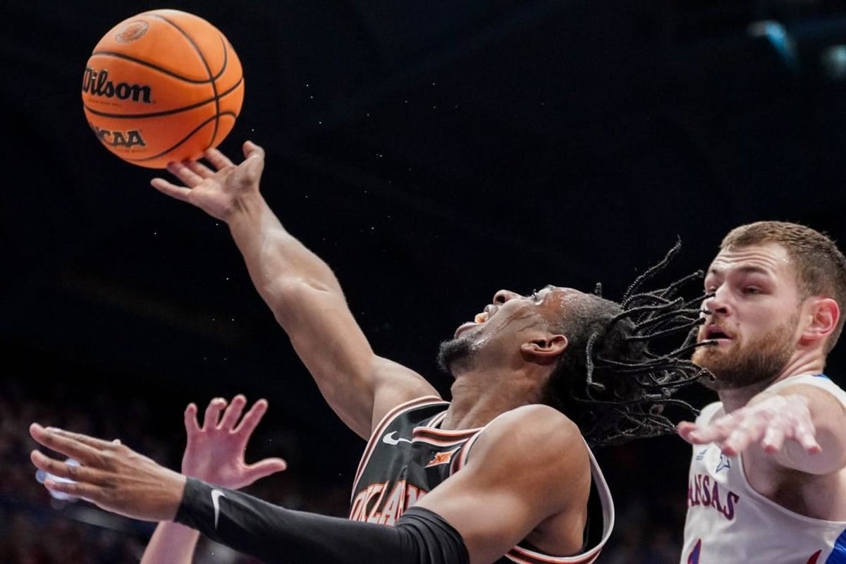 Jan 30, 2024; Lawrence, Kansas, USA; Oklahoma State Cowboys guard Jarius Hicklen (4) shoots as Kansas Jayhawks center Hunter Dickinson (1) defends during the first half at Allen Fieldhouse.