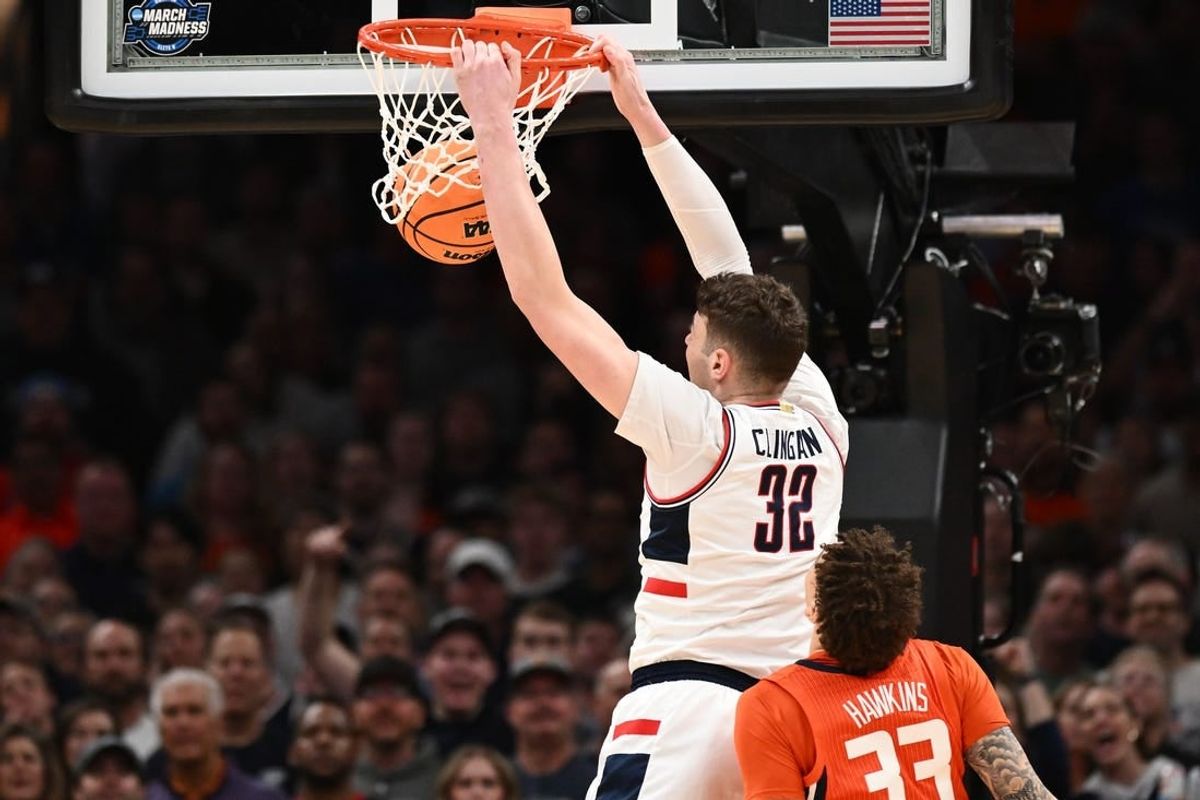 Mar 30, 2024; Boston, MA, USA; Connecticut Huskies center Donovan Clingan (32) dunks the ball against Illinois Fighting Illini forward Coleman Hawkins (33) in the finals of the East Regional of the 2024 NCAA Tournament at TD Garden.