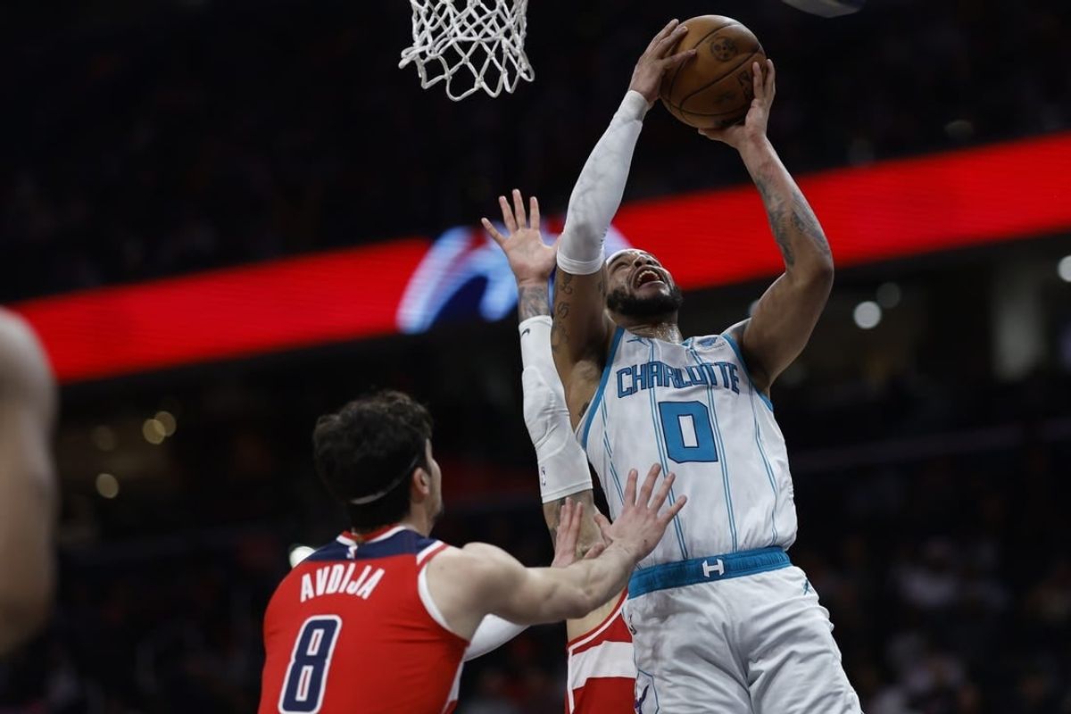 Mar 8, 2024; Washington, District of Columbia, USA; Charlotte Hornets forward Miles Bridges (0) shoots the ball as Washington Wizards forward Kyle Kuzma (33) and Wizards forward Deni Avdija (8) defend in the second half at Capital One Arena.