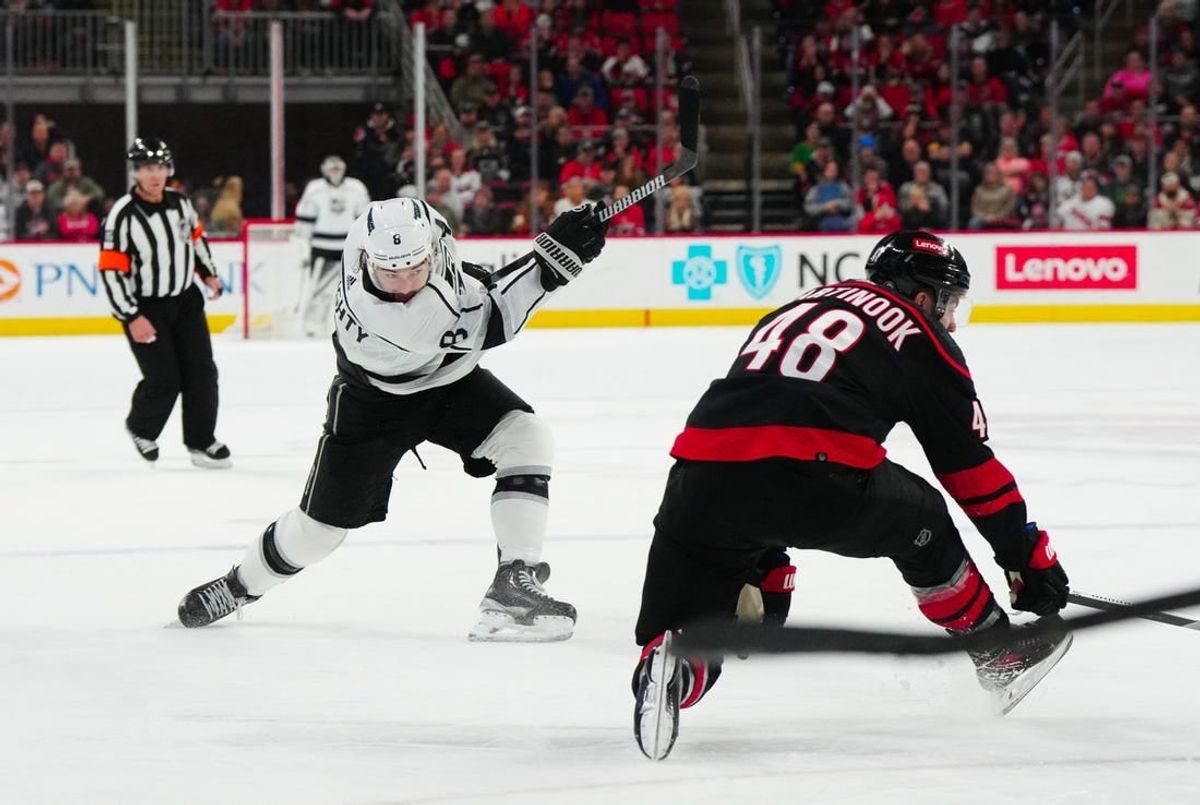 Jan 15, 2024; Raleigh, North Carolina, USA; Los Angeles Kings defenseman Drew Doughty (8) takes a shot past Carolina Hurricanes left wing Jordan Martinook (48) during the second period at PNC Arena.