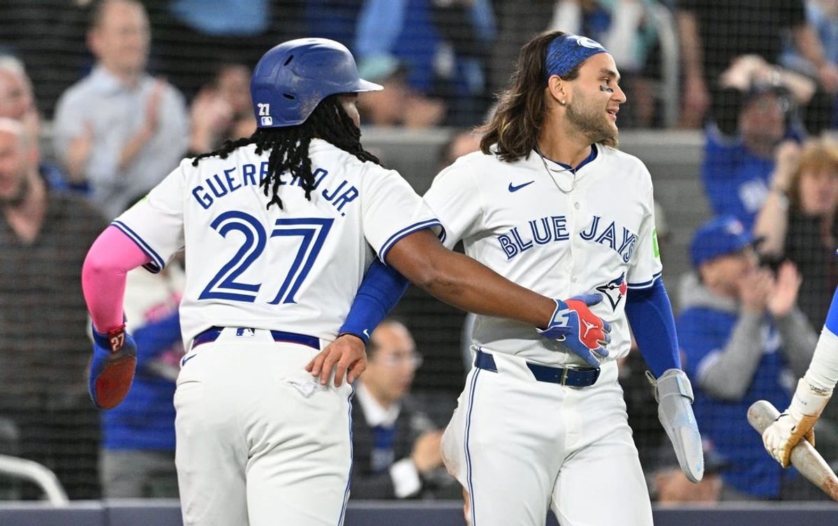 Apr 8, 2024; Toronto, Ontario, CAN;  Toronto Blue Jays first baseman Vladimir Guerrero Jr. (27) and shortstop Bo Bichette (11) celebrate after scoring against the Seattle Mariners in the third inning at Rogers Centre.