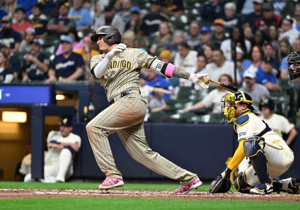 Apr 15, 2024; Milwaukee, Wisconsin, USA; San Diego Padres third base Manny Machado (13) gets a hit against the Milwaukee Brewers in the fifth inning at American Family Field. All players wore #42 in honor of Jackie Robinson Day.