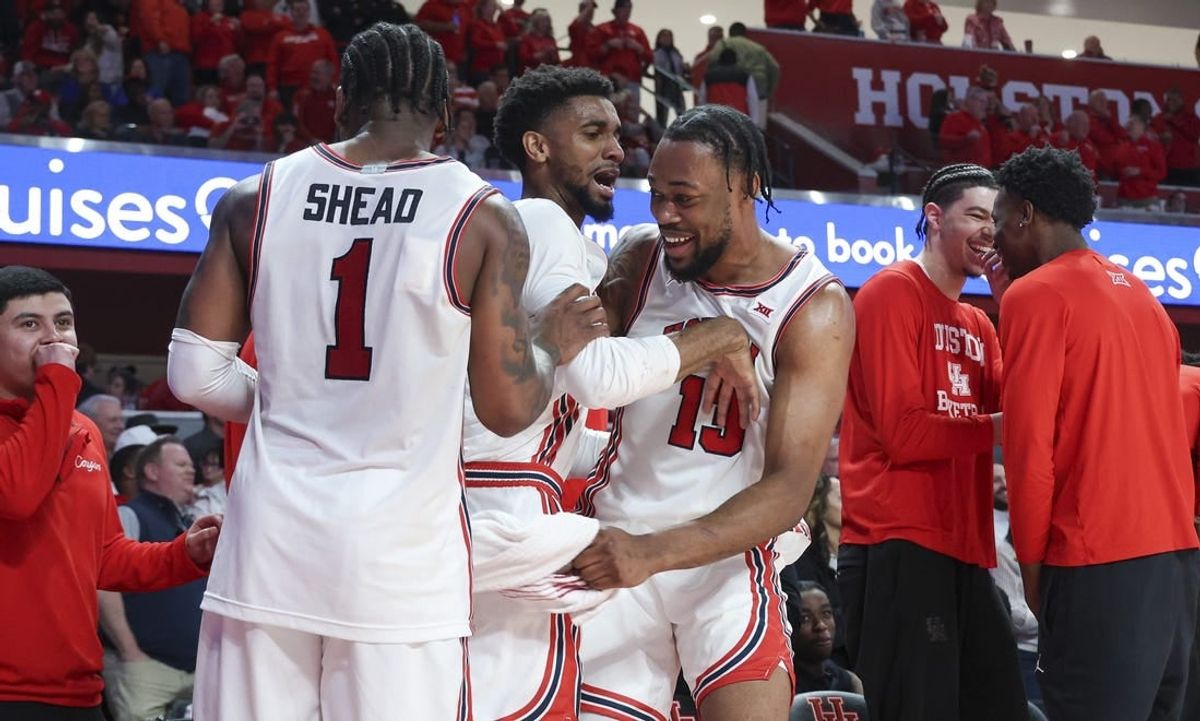 Mar 9, 2024; Houston, Texas, USA; Houston Cougars forward J'Wan Roberts (13) celebrates with guard Mylik Wilson (8) and guard Jamal Shead (1) in the final minute of the game against the Kansas Jayhawks at Fertitta Center.