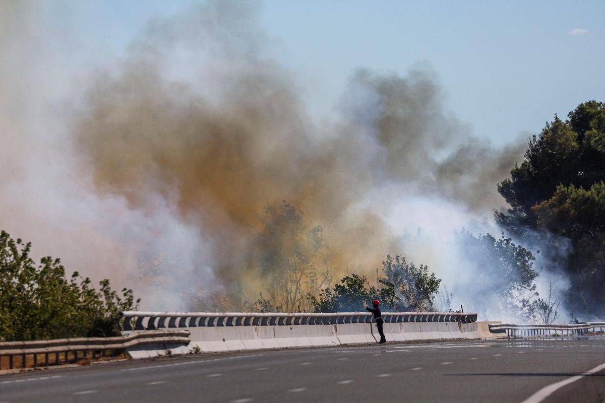 A firefighter works to battle wildfire near the A9 motorway near Beziers, France, July 3, 2026.