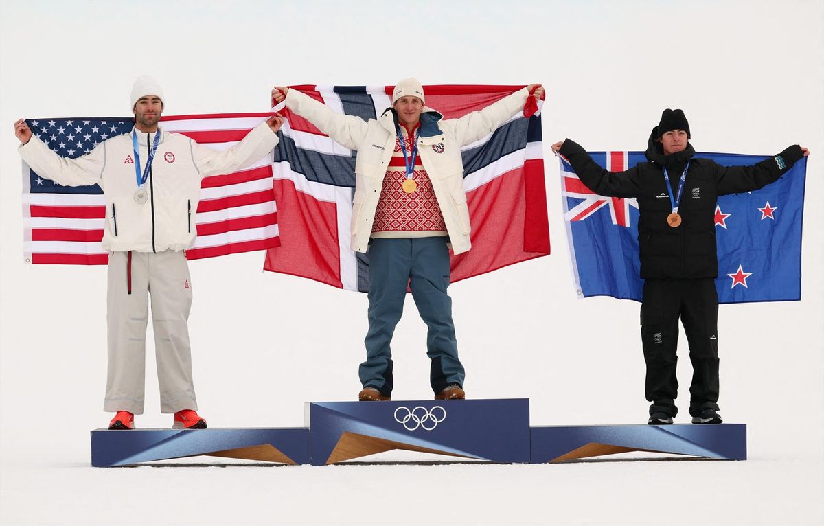 Livigno, Italy - February 10, 2026. Gold medalist Birk Ruud of Norway celebrates on the podium after winning the Men's Freeski Slopestyle with silver medalist Alex Hall of United States and bronze medalist Luca Harrington of New Zealand