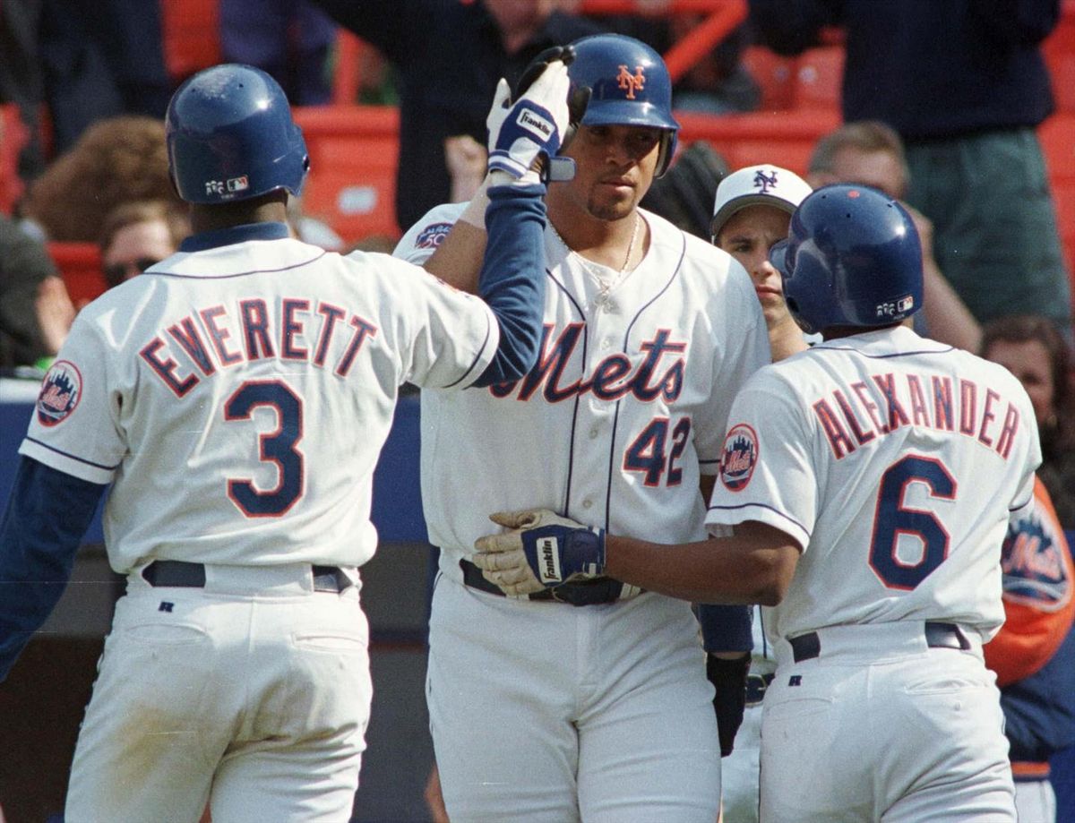 New York Mets Carl Everett (L) and Manny Alexander (R) are congratulated by teammate Butch Huskey (C) after scoring in the eighth inning of play against the Colorado Rockies in New York on May 18, 1997. The Rockies blew a 4-2 lead, giving up eight runs in the eighth, to lose the game 10-4. Huskey went three for five with two runs-batted-in for the day.