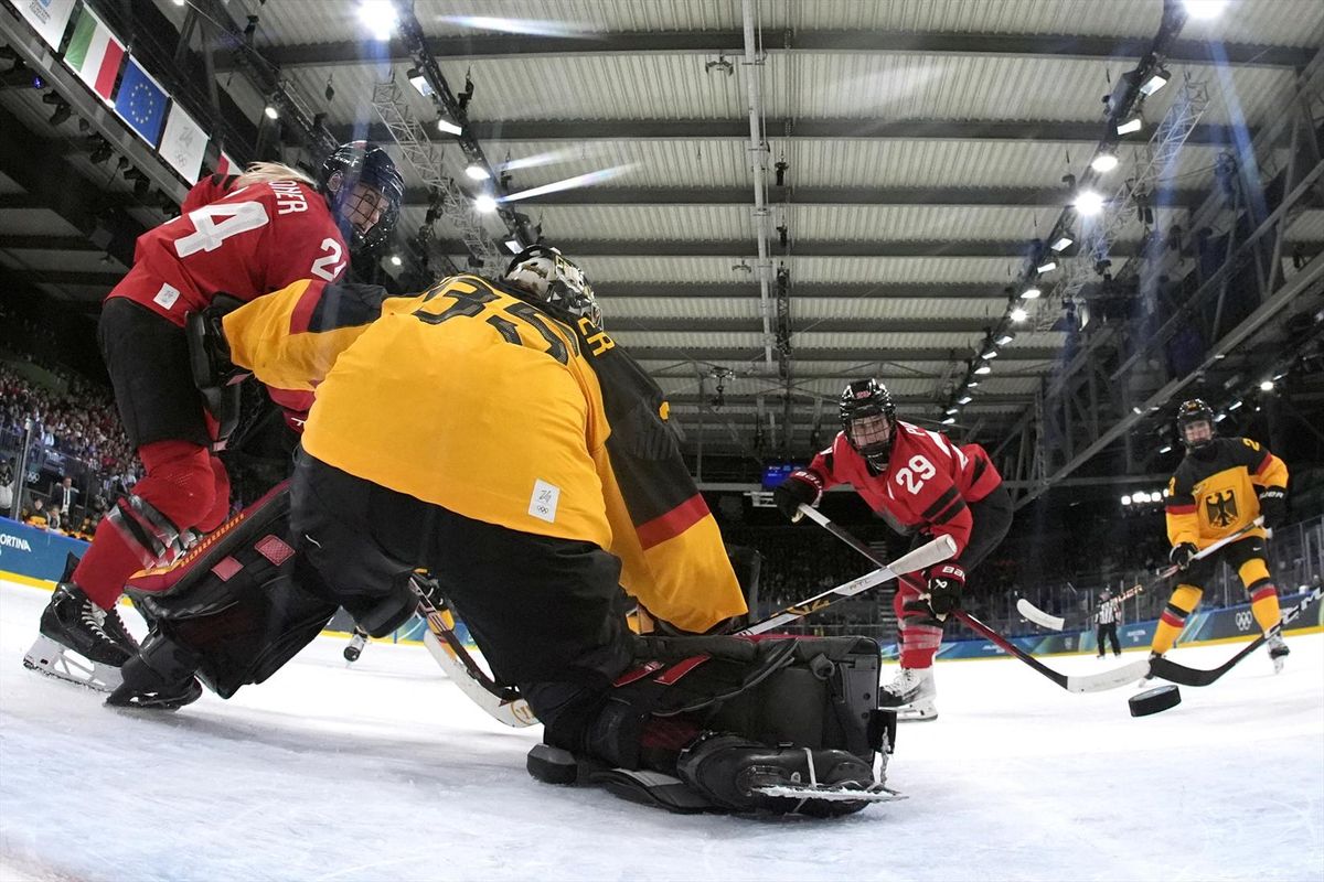 Marie-Philip Poulin of Canada scores the team's fifth goal past Sandra Abstreiter of Germany on Saturday to advance to the semifinals of the Milan Cortina Olympics.