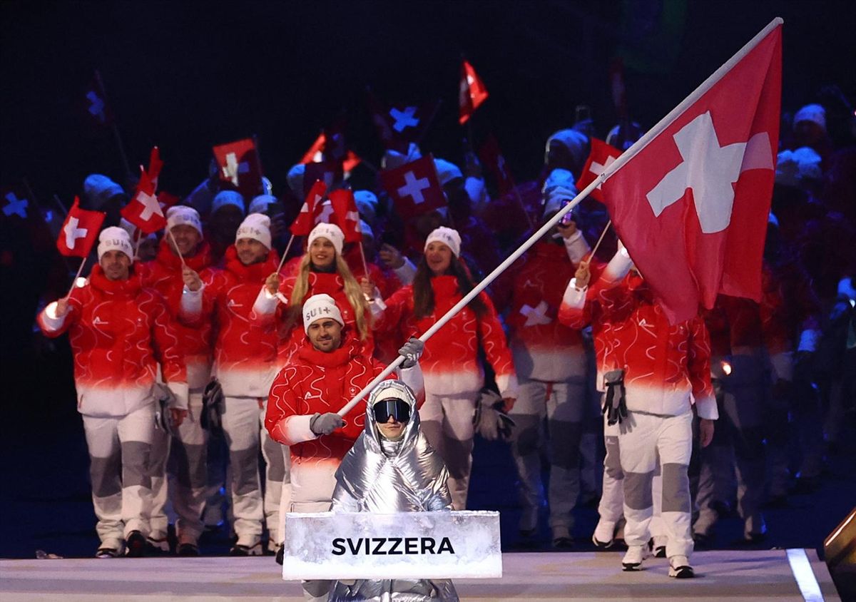 Flagbearer Nino Niederreiter of Switzerland leads their contingent in the athletes parade during the opening ceremony on Friday in Milan.