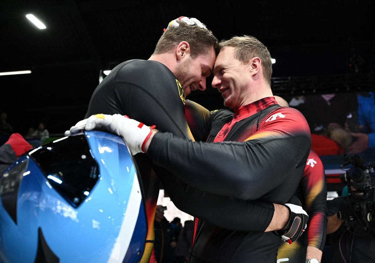 Johannes Lochner of Germany celebrates after winning the gold medal with silver medalist Francesco Friedrich of Germany in the four-man bobsled on Sunday in the Milan Cortina Olympics.