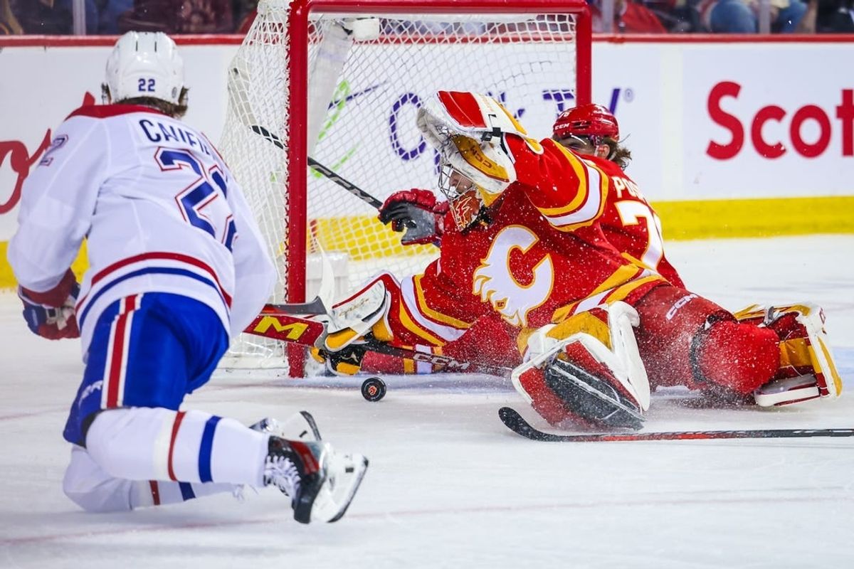 Mar 16, 2024; Calgary, Alberta, CAN; Calgary Flames goaltender Dustin Wolf (32) makes a save against Montreal Canadiens right wing Cole Caufield (22) during the first period at Scotiabank Saddledome.
