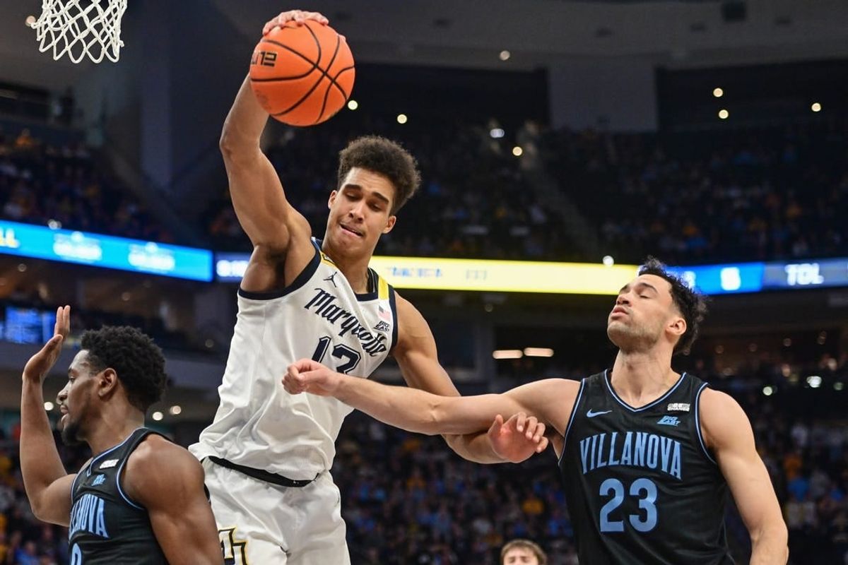 Jan 15, 2024; Milwaukee, Wisconsin, USA; Marquette Golden Eagles forward Oso Ighodaro (13) and Villanova Wildcats forward Tyler Burton (23) reach for a rebound in the second half at Fiserv Forum.