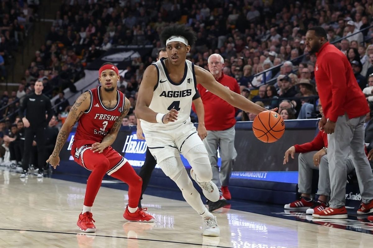 Jan 20, 2024; Logan, Utah, USA; Utah State Aggies guard Ian Martinez (4) drives past Fresno State Bulldogs guard Isaiah Hill (3) during the first half at Dee Glen Smith Spectrum.