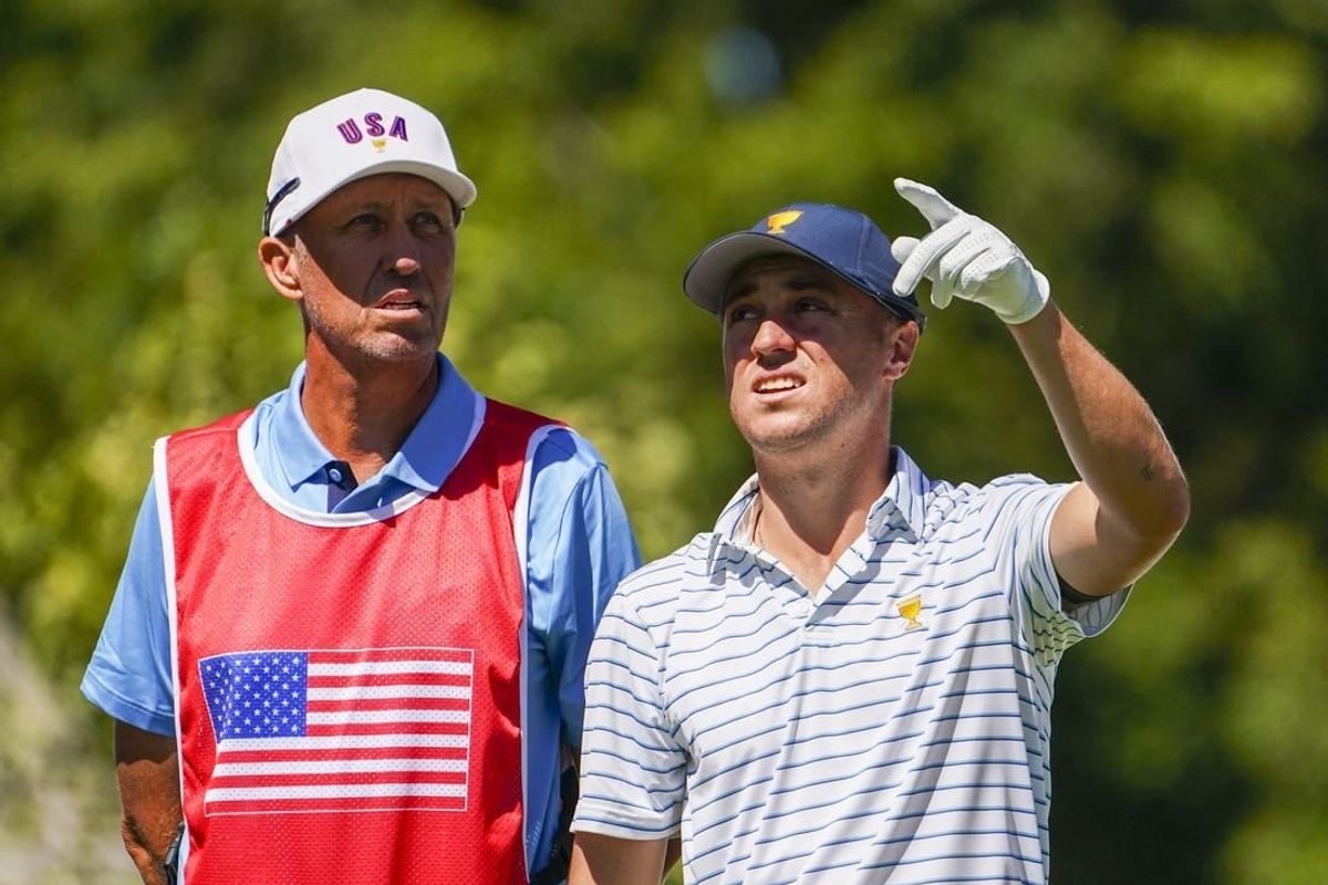 Sep 23, 2022; Charlotte, North Carolina, USA; Team USA golfer Justin Thomas (right) talks to caddie Jim Mackay (left) on the fourth hole during the four-ball match play of the Presidents Cup golf tournament at Quail Hollow Club.