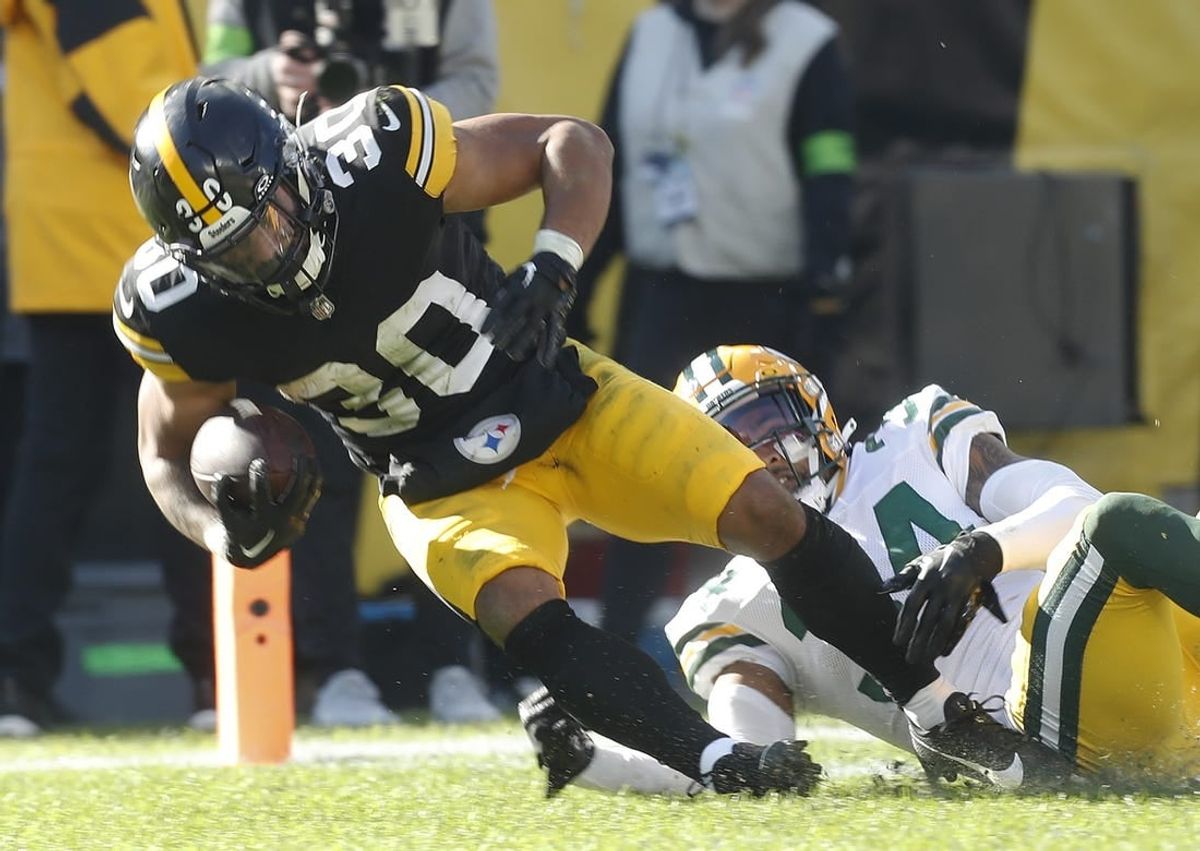Nov 12, 2023; Pittsburgh, Pennsylvania, USA;  Pittsburgh Steelers running back Jaylen Warren (30) scores on a sixteen yard touchdown run past Green Bay Packers safety Jonathan Owens (34) during the second quarter at Acrisure Stadium.