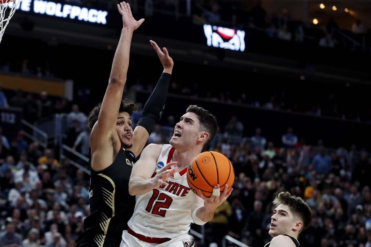 Mar 23, 2024; Pittsburgh, PA, USA; North Carolina State Wolfpack guard Michael O'Connell (12) shoots the ball against Oakland Golden Grizzlies forward Trey Townsend (4) during the second half in the second round of the 2024 NCAA Tournament at PPG Paints Arena.