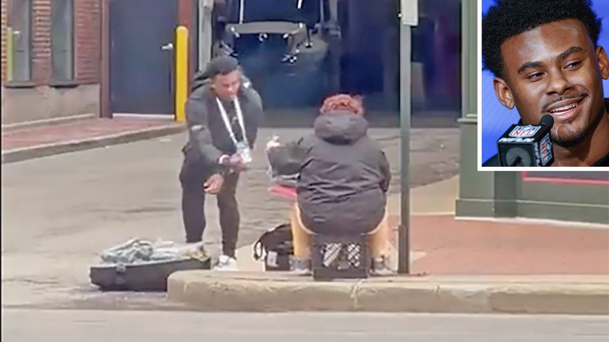 Former Liberty QB Malik Willis giving aid to a man sitting on a street corner.