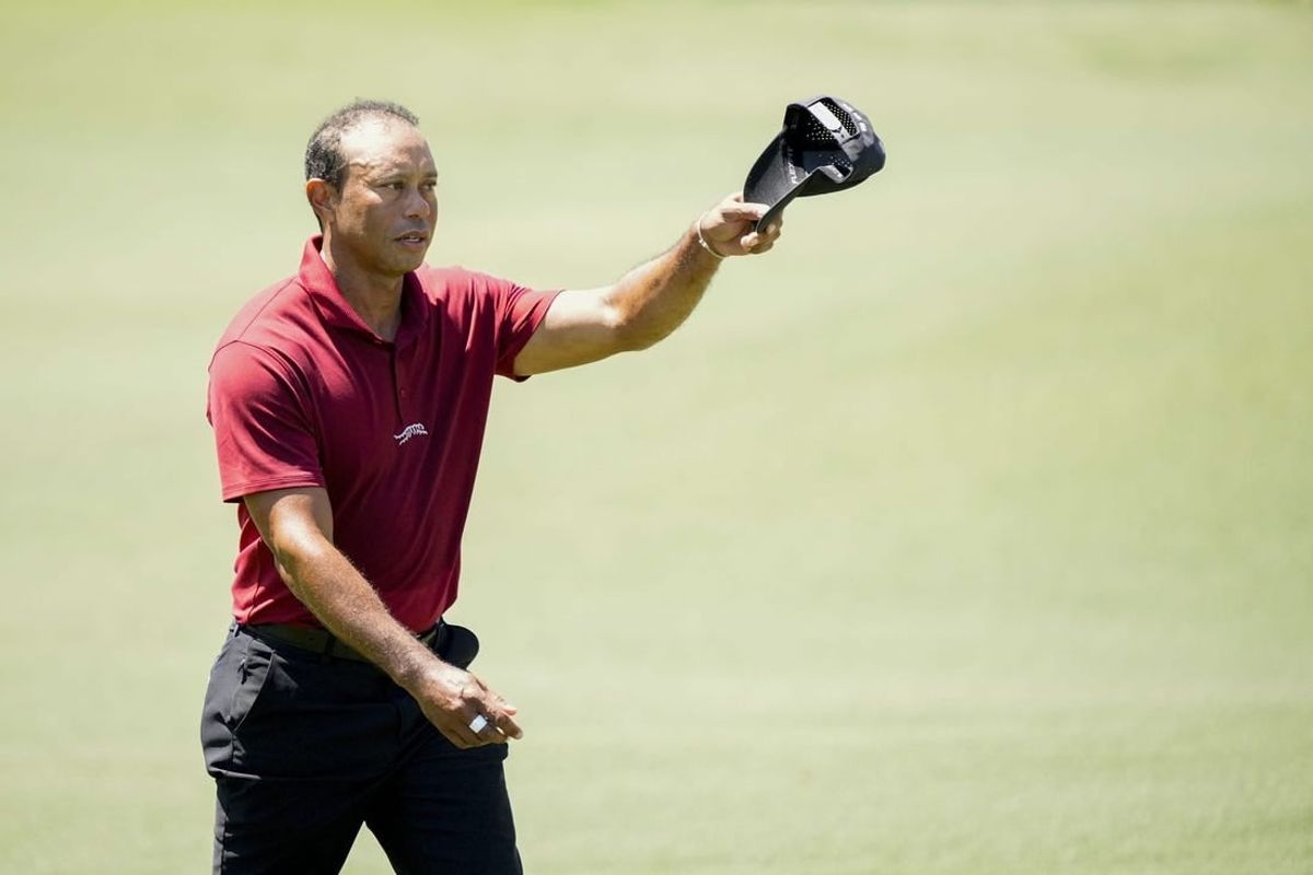 Apr 14, 2024; Augusta, Georgia, USA; Tiger Woods tips his hat to patrons as he walks up No. 18 during the final round of the Masters Tournament.