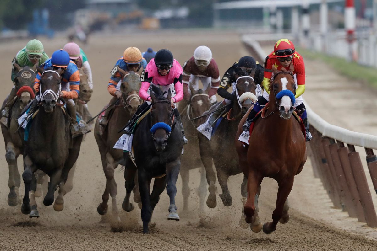 Justify and Mike Smith lead heading into the far turn, flanked by Restoring Hope and Florent Geroux.