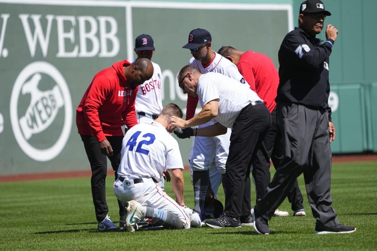 Apr 15, 2024; Boston, Massachusetts, USA; Boston Red Sox trainers attend to Boston Red Sox left fielder Tyler O'Neill (42) after he collided with Boston Red Sox third baseman Rafael Devers (not pictured) during the seventh inning against the Cleveland Guardians at Fenway Park.