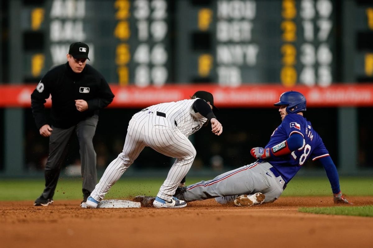 May 10, 2024; Denver, Colorado, USA; Texas Rangers catcher Jonah Heim (28) is tagged out attempting to reach second against Colorado Rockies second baseman Brendan Rodgers (7) in the sixth inning at Coors Field.