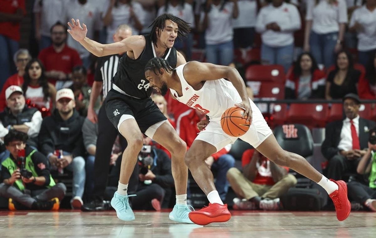Dec 6, 2023; Houston, Texas, USA; Houston Cougars forward J'Wan Roberts (13) drives with the ball as Rice Owls forward Keanu Dawes (24) defends during the first half at Fertitta Center.