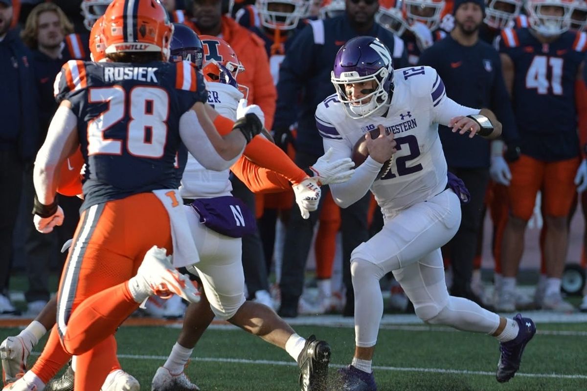 Nov 25, 2023; Champaign, Illinois, USA; Northwestern Wildcats quarterback Jack Lausch (12) rushes with the ball  during the first half against the Illinois Fighting Illini at Memorial Stadium.