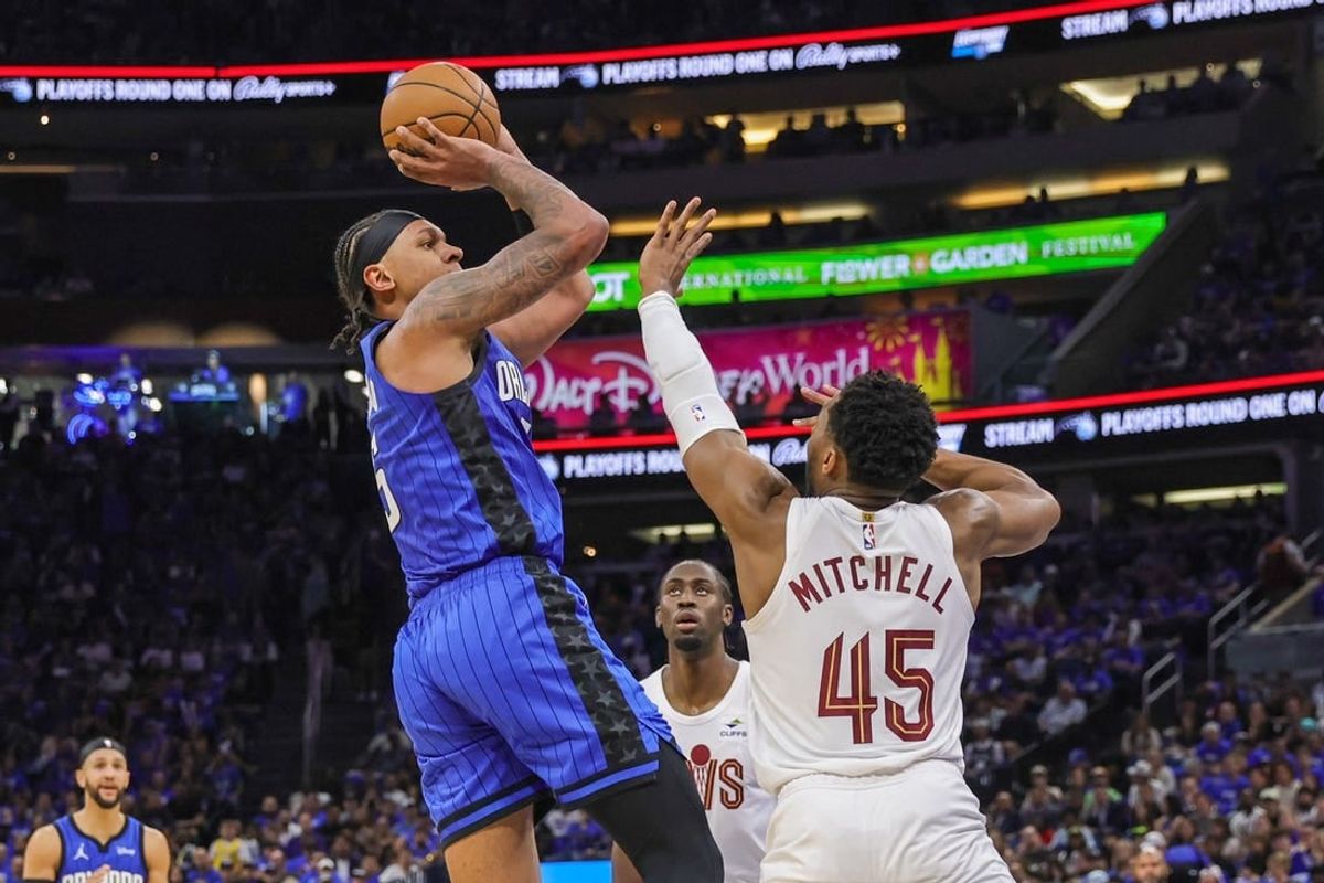 Apr 25, 2024; Orlando, Florida, USA; Orlando Magic forward Paolo Banchero (5) shoots the ball against Cleveland Cavaliers guard Donovan Mitchell (45) during the second quarter of game three of the first round for the 2024 NBA playoffs at Kia Center.